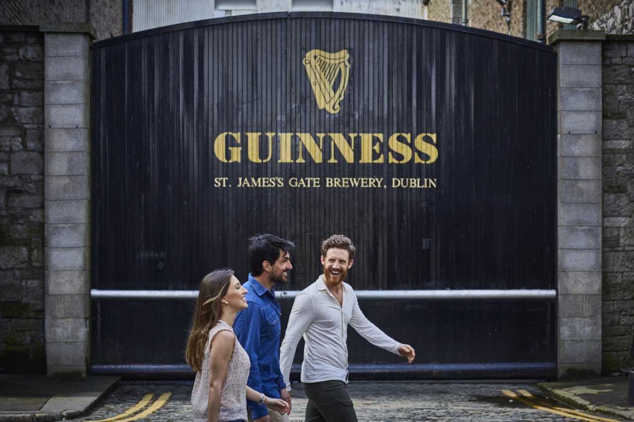 three people walking in front of the guinness storehouse tour